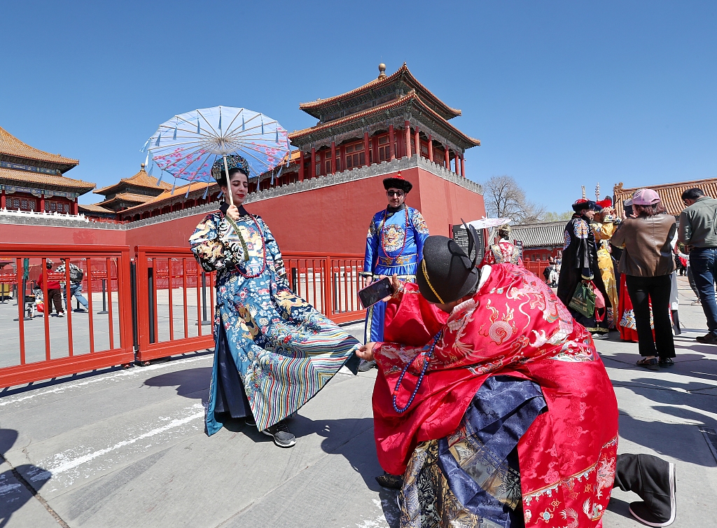 International visitors wearing hanfu attire pose for photos at the Palace Museum in Beijing on March 22, 2024. /CFP