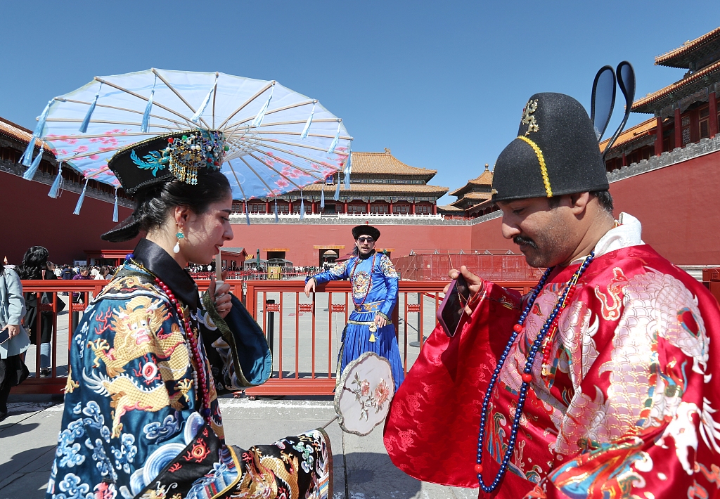International visitors wearing hanfu attire pose for photos at the Palace Museum in Beijing on March 22, 2024. /CFP