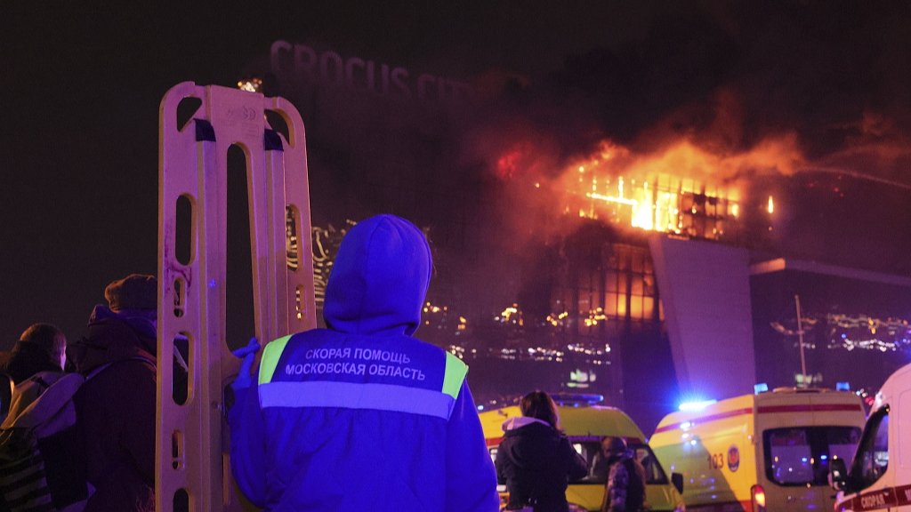 A medic stands near ambulances parked outside the burning building of the Crocus City Hall on the western edge of Moscow, Russia, March 22, 2024. /CFP