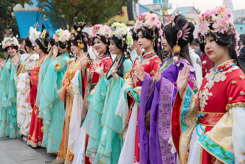 Young people participating in a traditional Chinese costume parade pose for photos at Happy Valley Shanghai as a 