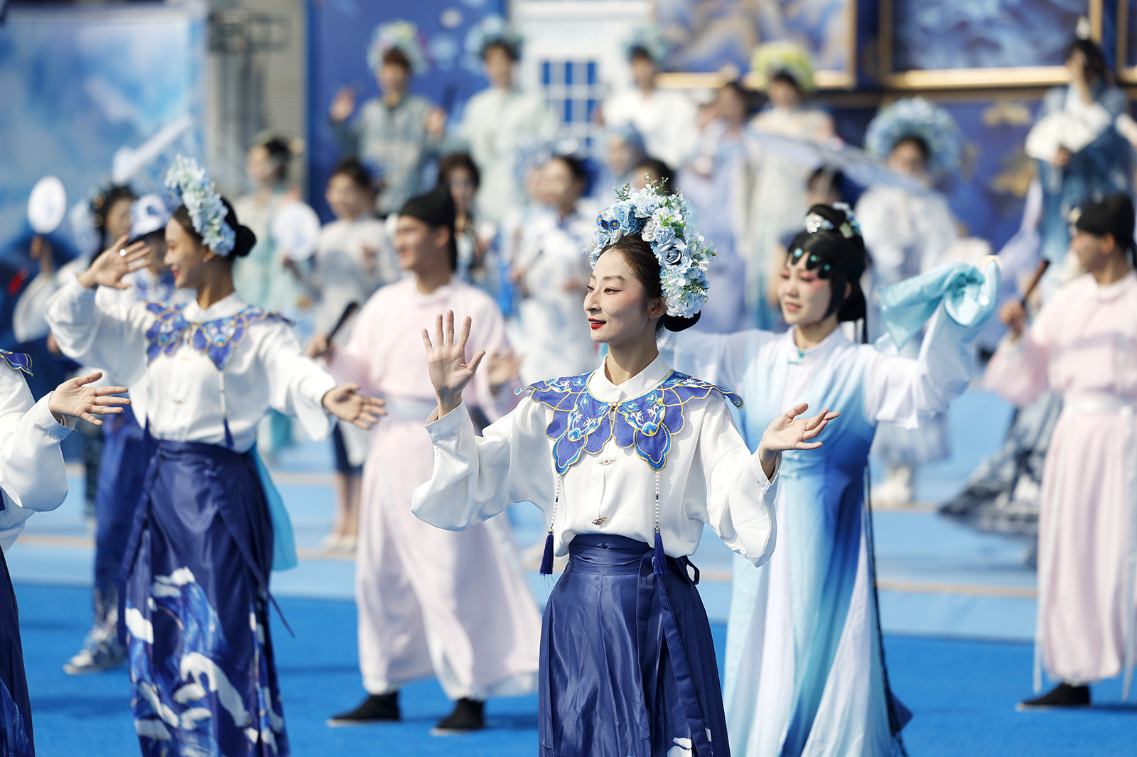 Young people dressed in costumes featuring patterns of Chinese blue and white porcelain perform at Happy Valley Beijing as a 