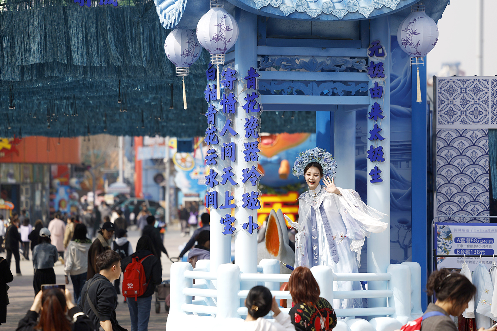 A young woman dressed in costume featuring patterns of Chinese blue and white porcelain waves at Happy Valley Beijing as a 