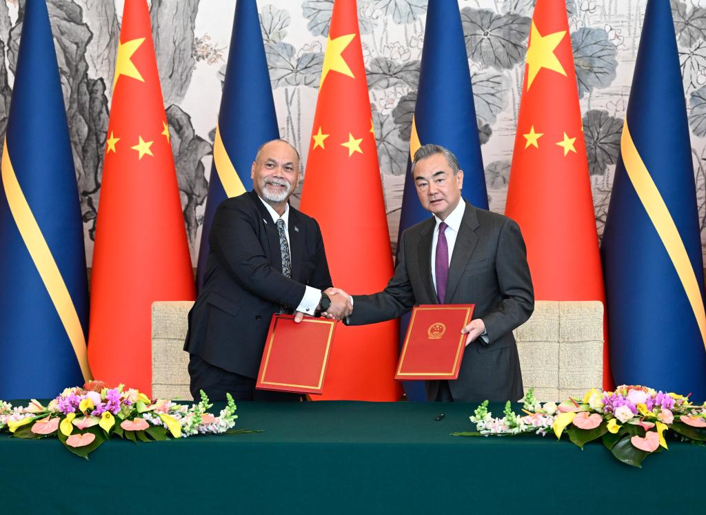 Chinese Foreign Minister Wang Yi (R), also a member of the Political Bureau of the Communist Party of China Central Committee, shakes hands with Nauru's Minister for Foreign Affairs and Trade Lionel Aingimea, after signing a joint communique on the resumption of bilateral diplomatic relations at the ambassadorial level in Beijing, capital of China, January 24, 2024. /Xinhua