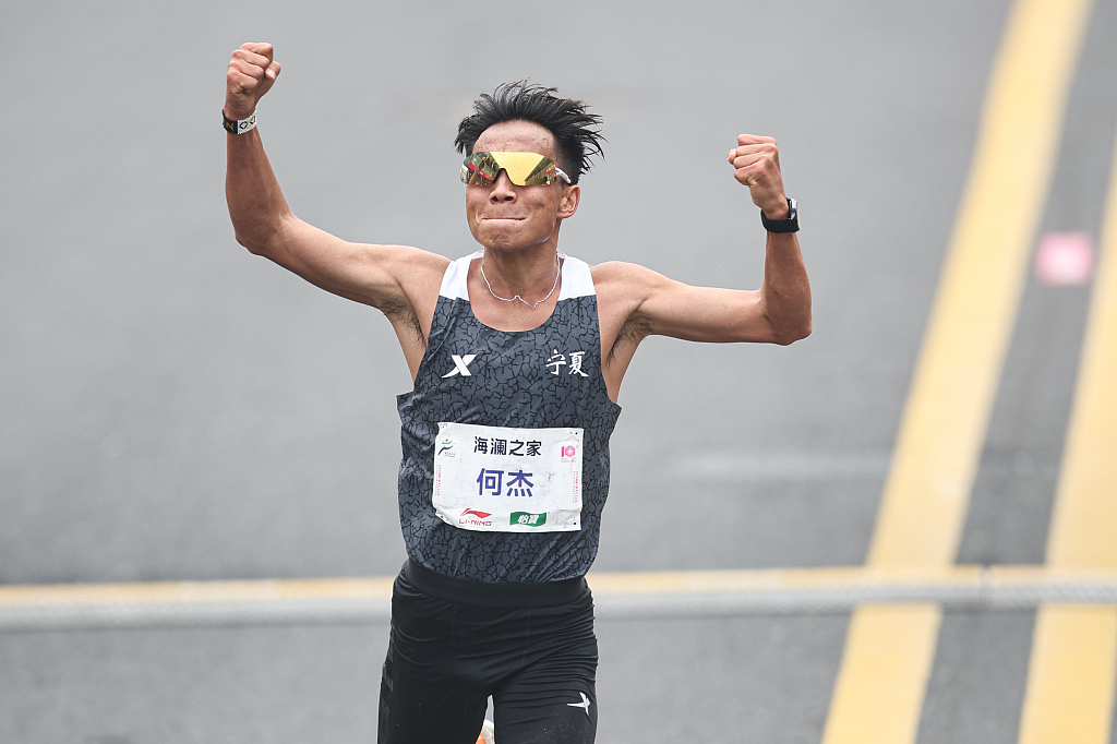 He Jie of China celebrates after lowering the national men's marathon record to two hours, six minutes and 57 seconds during the Wuxi Marathon in Wuxi, China, March 24, 2024. /CFP