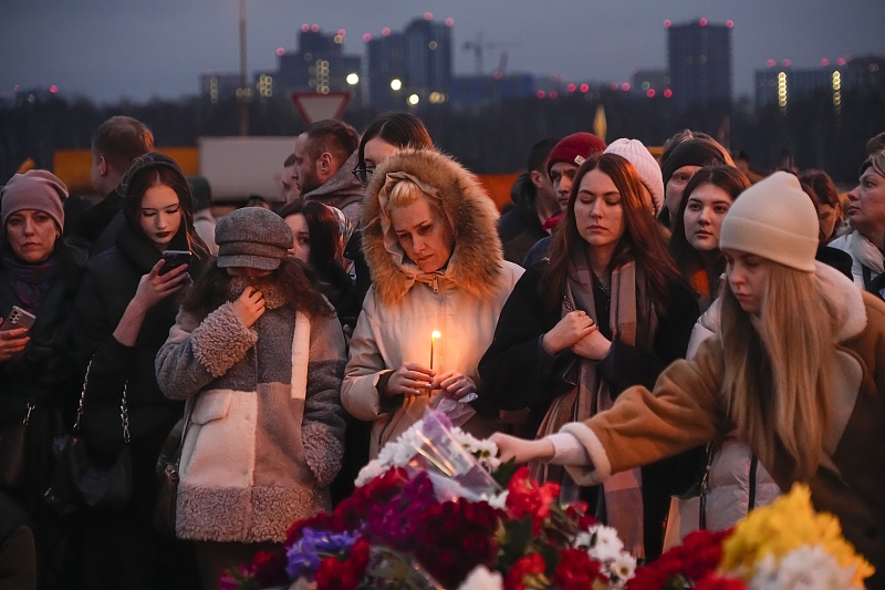 People lay flowers and light candles standing next to the Crocus City Hall, on the western edge of Moscow, Russia, March 23, 2024. /CFP