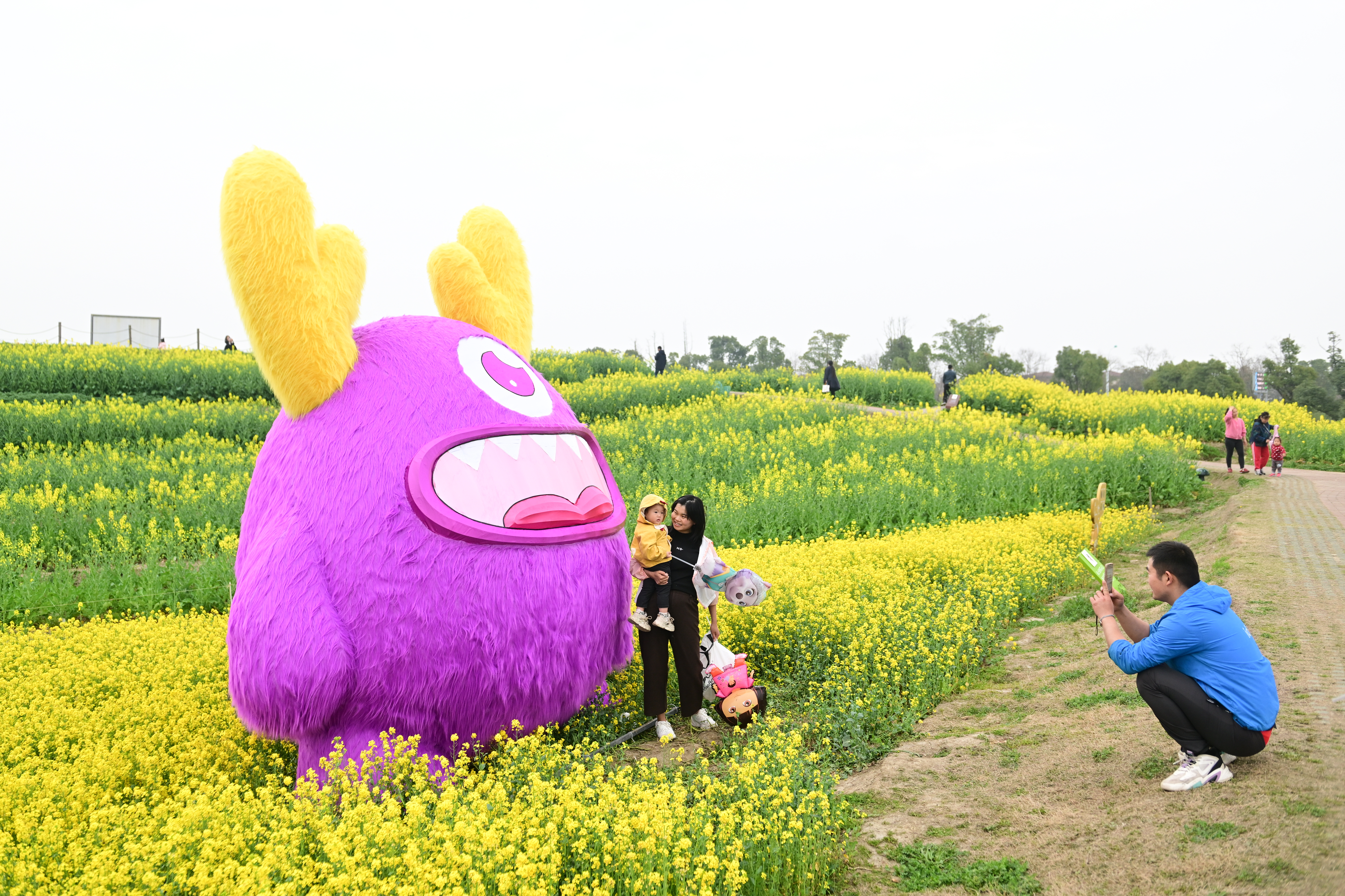 A family takes photos in front of a giant doll at the Peninsula Pastoral, a fun-filled vegetable and plant exploration park in Suzhou, east China's Jiangsu Province, on March 24, 2024. /IC