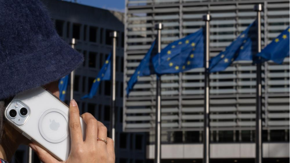 A woman uses an iPhone at the Berlaymont building, headquarters of the European Commission, in Brussels, Belgium, March 4, 2024. /Xinhua