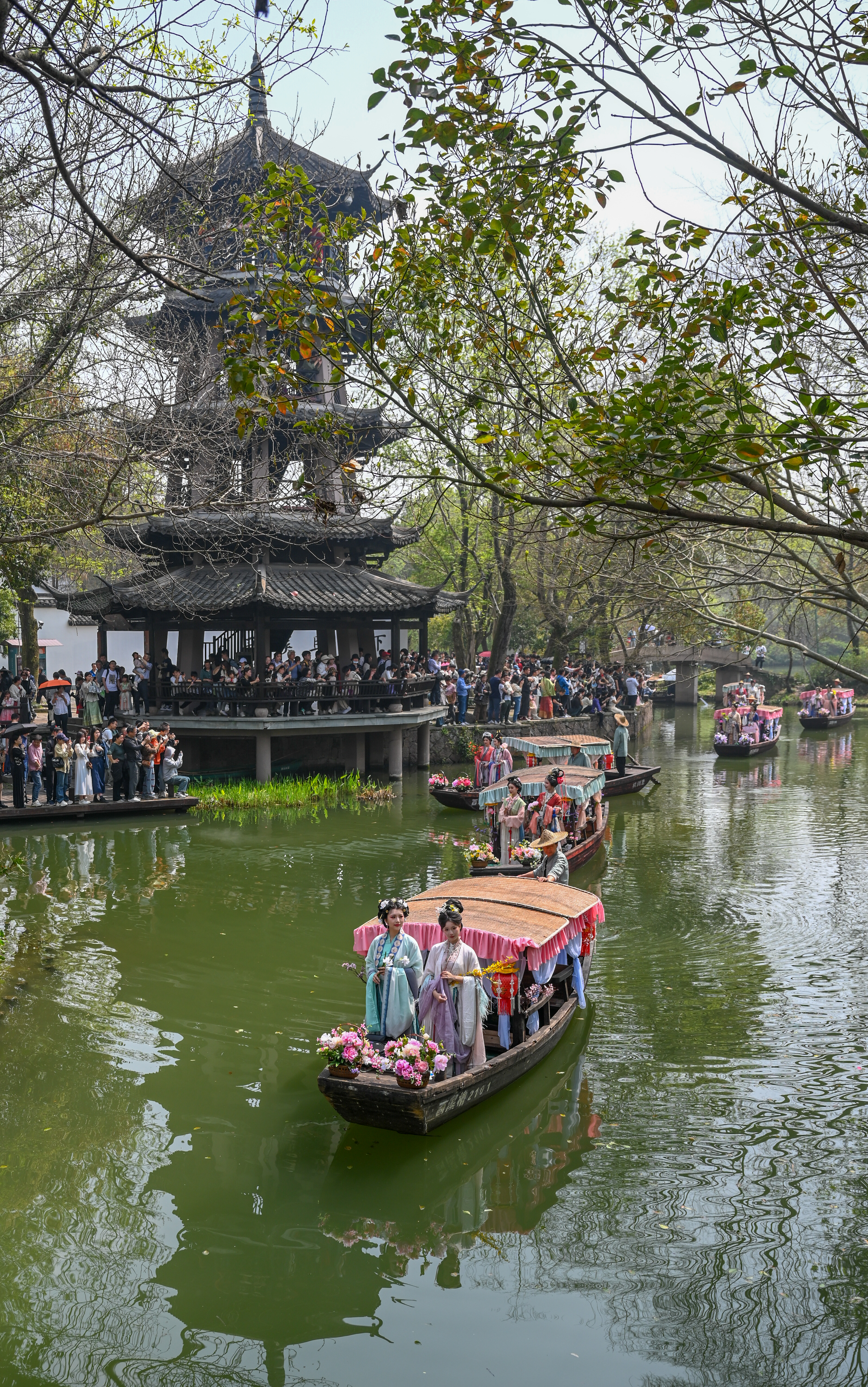 Participants adorned in traditional hanfu attire join a boat parade as part of local Huazhao Festival celebrations at the Xixi National Wetland Park in Hangzhou, east China's Zhejiang Province, March 24, 2024. /IC