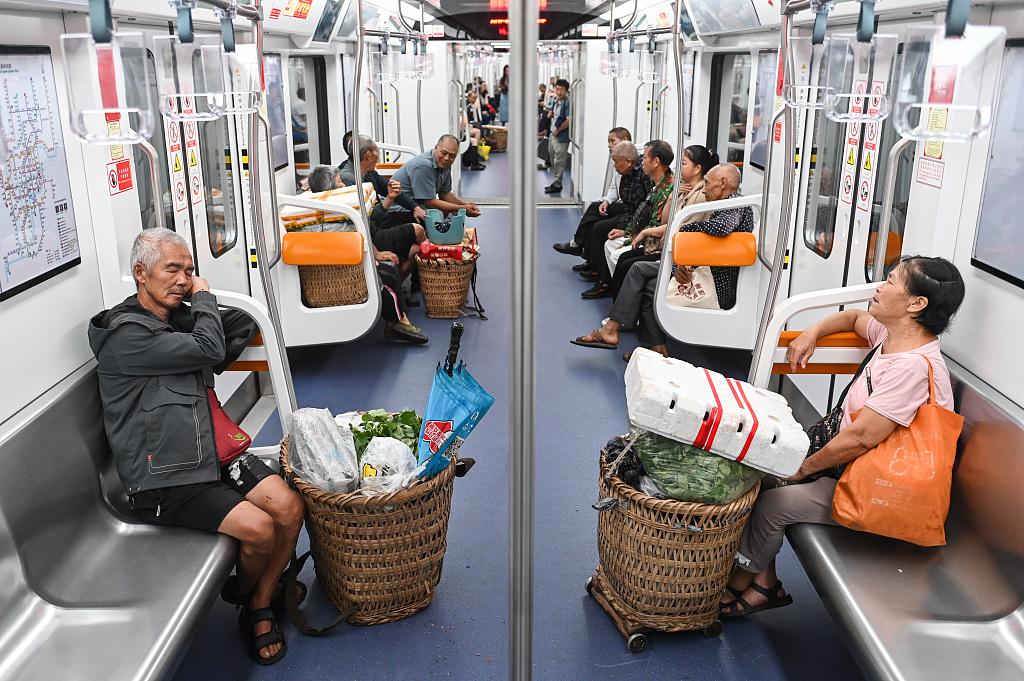 A file photo shows farmers carrying baskets filled with fresh produce on Chongqing’s subway Line 4. /CFP