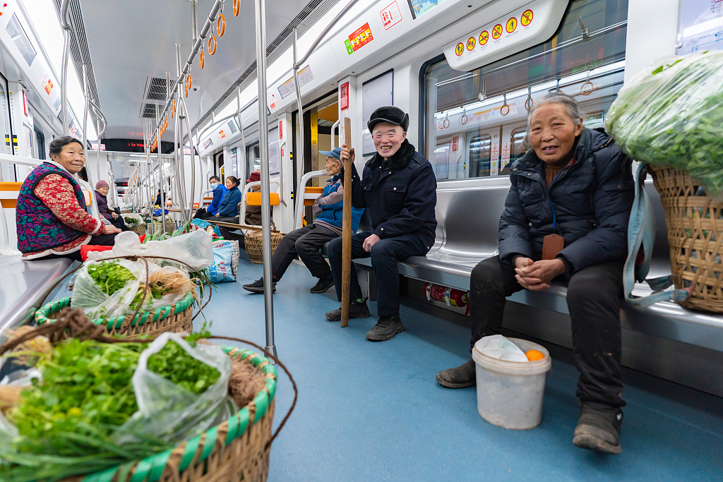 A file photo shows farmers carrying bamboo baskets filled with vegetables on Chongqing’s subway Line 4. /CFP