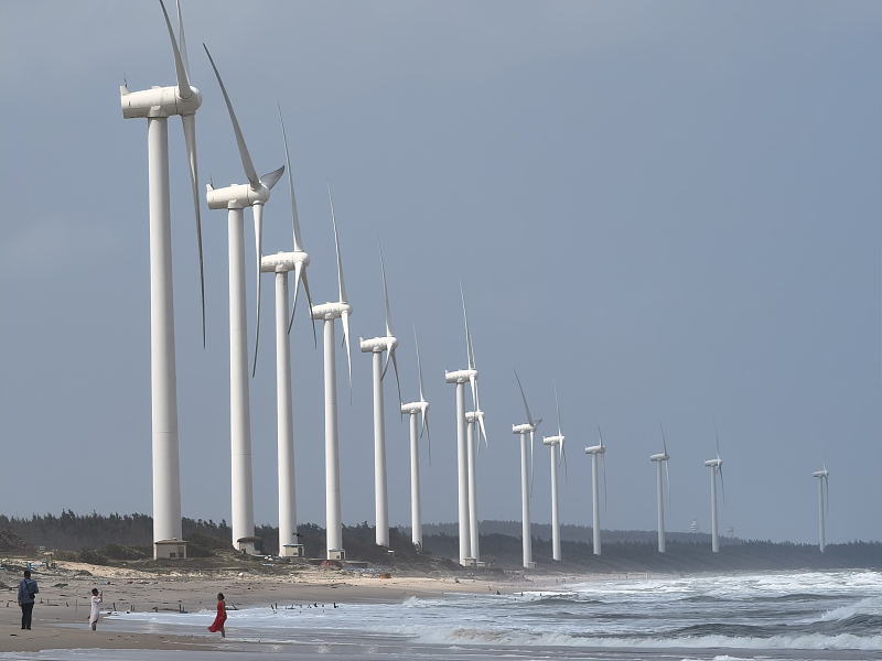 Tourists seen near wind turbines in Wenchang City, south China's Hainan Province. /CFP