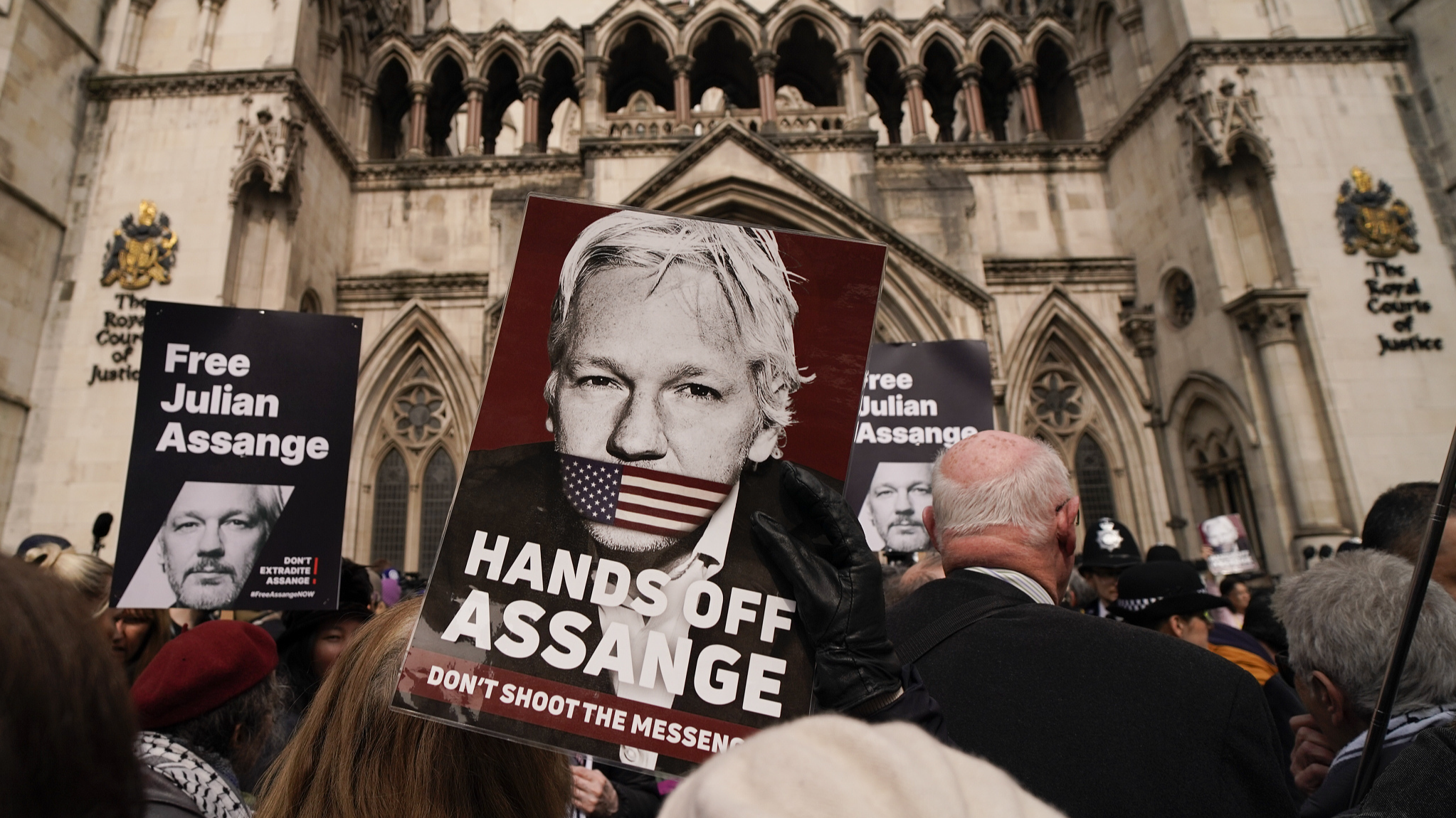 A demonstrator holds a placard after Stella Assange, wife of Wikileaks founder Julian Assange, released a statement outside the Royal Courts of Justice, in London, UK, March 26, 2024. /CFP