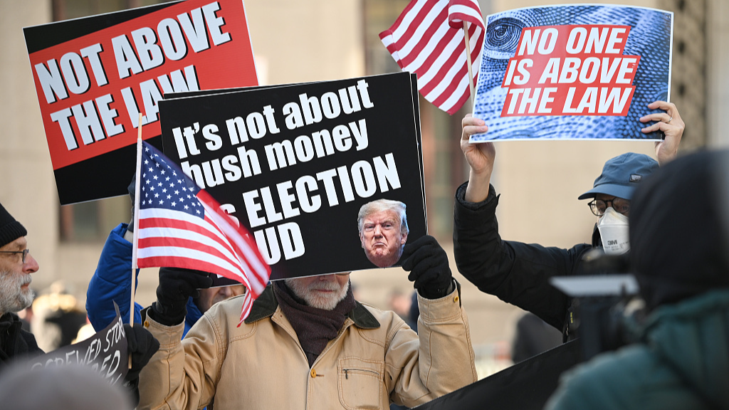 Protestors with signs stand outside New York County Criminal Court in New York City, U.S., March 25, 2024. /CFP