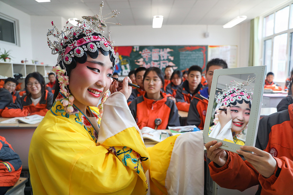 Students learn about the makeup of a traditional Chinese opera performer during class at a middle school in Zaozhuang, Shandong province, March 26, 2024. /CFP