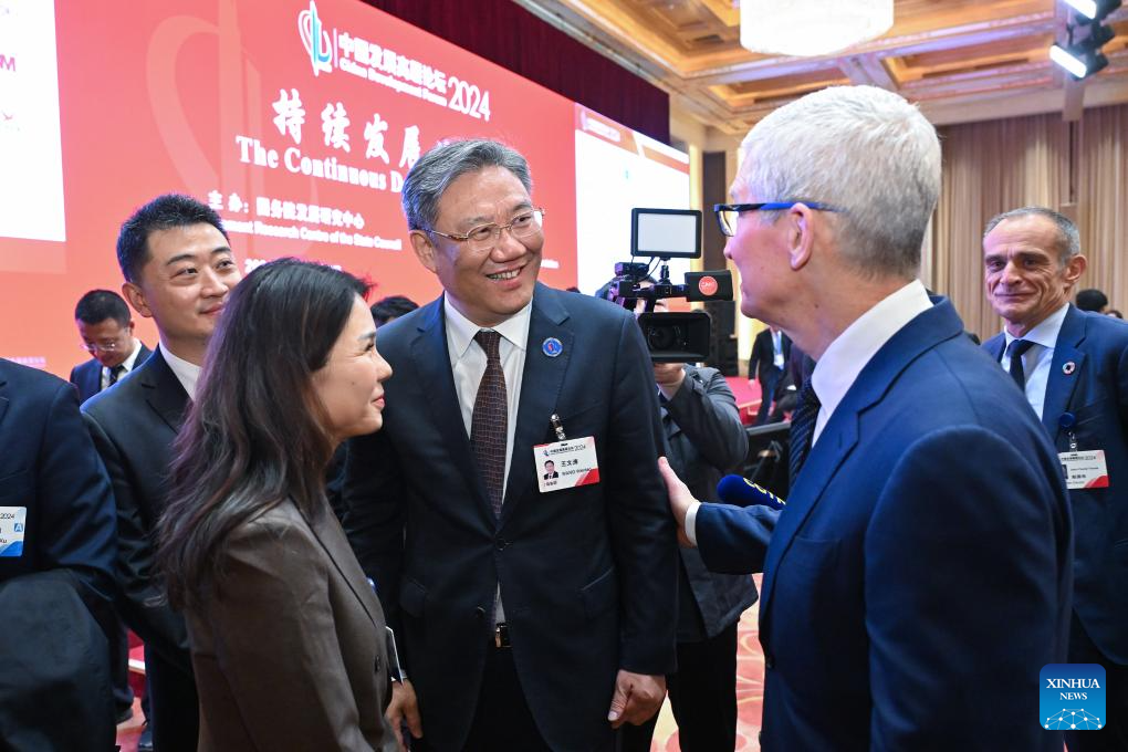 Chinese Commerce Minister Wang Wentao (C) talks with Apple CEO Tim Cook (2nd R) at the China Development Forum 2024 in Beijing, China, March 24, 2024. /Xinhua