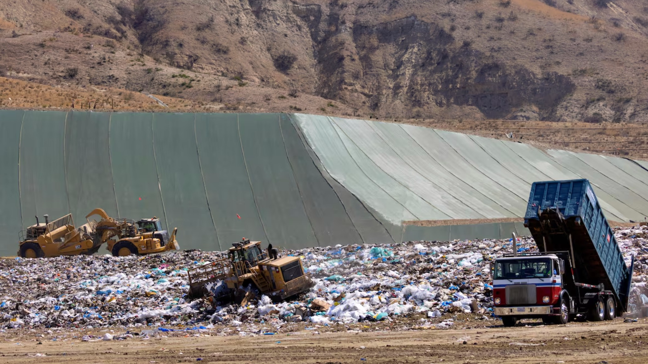 Workers use heavy machinery to move trash and waste at the Frank R. Bowerman landfill in Irvine, California, U.S., June 15, 2021. /Reuters