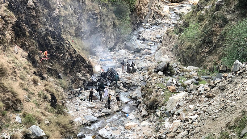 Security officials inspect the wreckage of a vehicle which was carrying Chinese nationals that plunged into a deep ravine off the mountainous Karakoram Highway after a suicide attack near Besham city in the Shangla district of Khyber Pakhtunkhwa province on March 26, 2024. /CFP