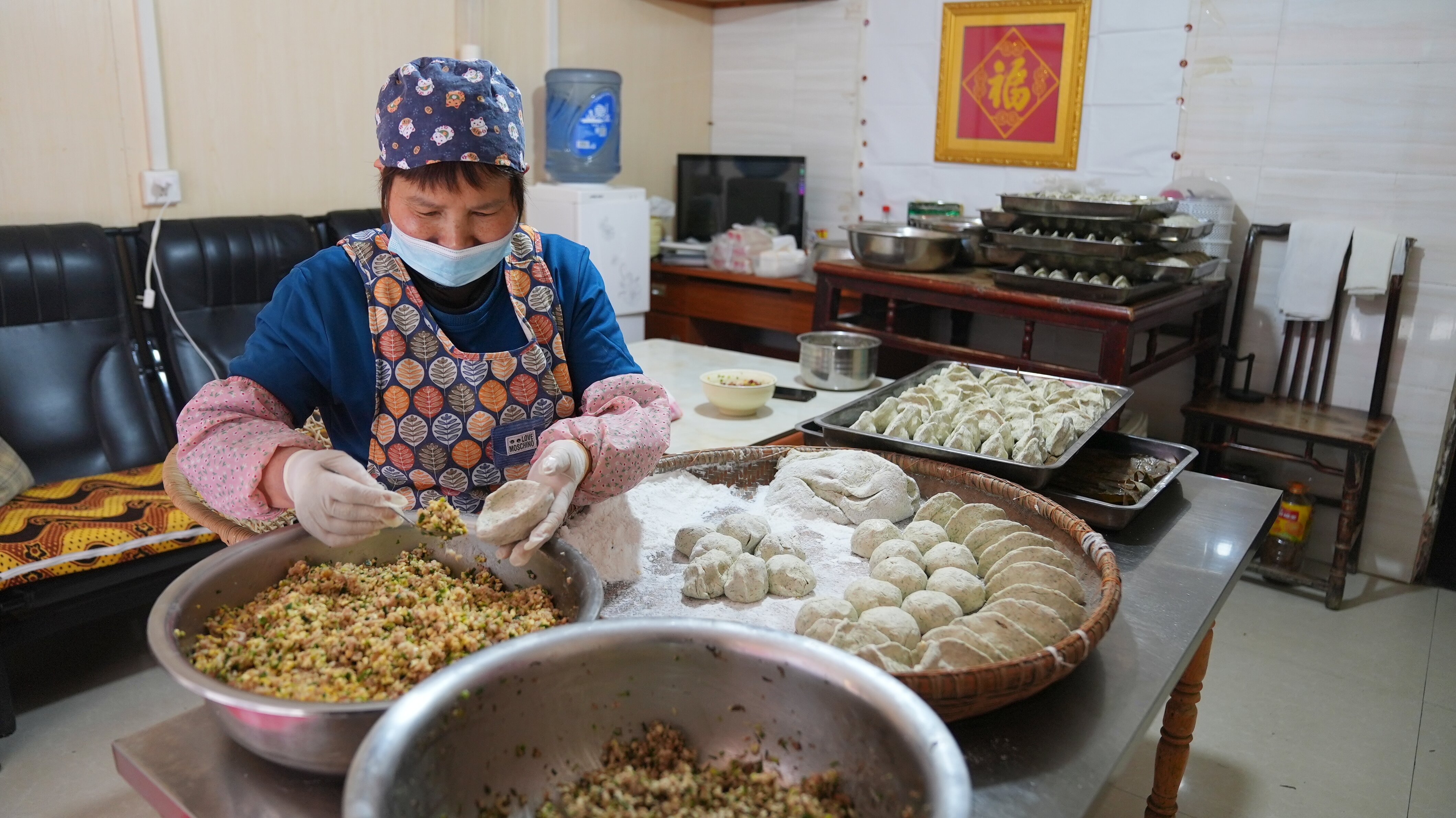 A photo shows a woman making Qingmingba at a workshop in Tongren, Guizhou Province. /Photo provided to CGTN