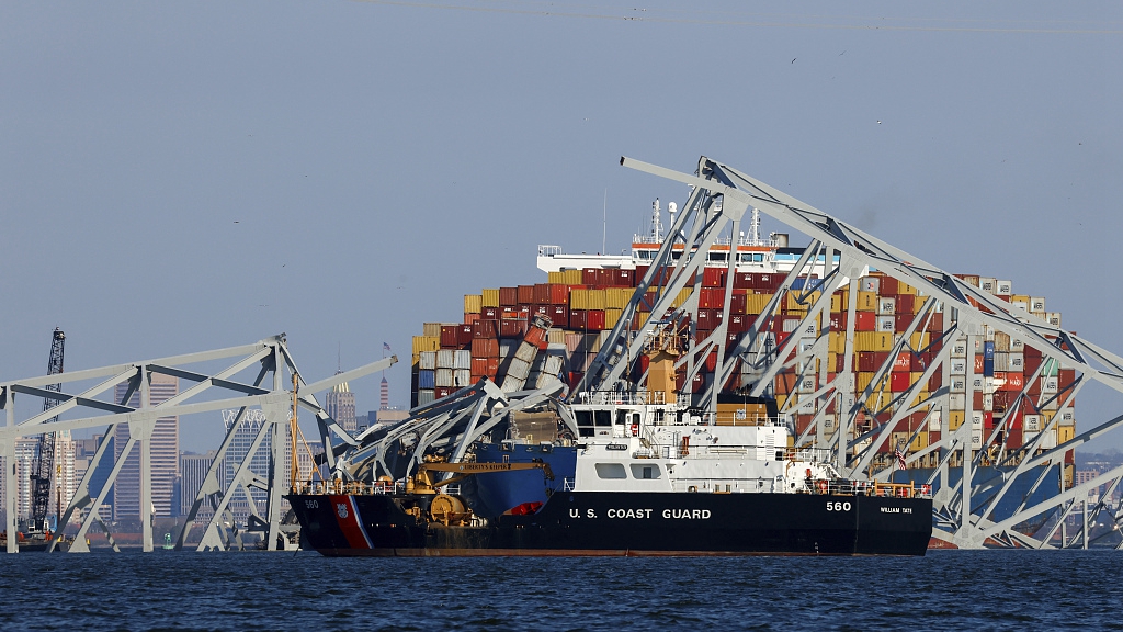 A U.S. Coast Guard coastal buoy tender passes by as wreckage of the Francis Scott Key Bridge rests on the container ship Dali in Baltimore, Maryland, U.S., March 30, 2024. /CFP