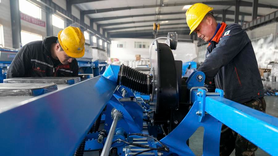 Staff members assemble a planter at the workshop of an agricultural machinery manufacturing enterprise in Jiamusi, northeast China's Heilongjiang Province, March 13, 2024. /Xinhua