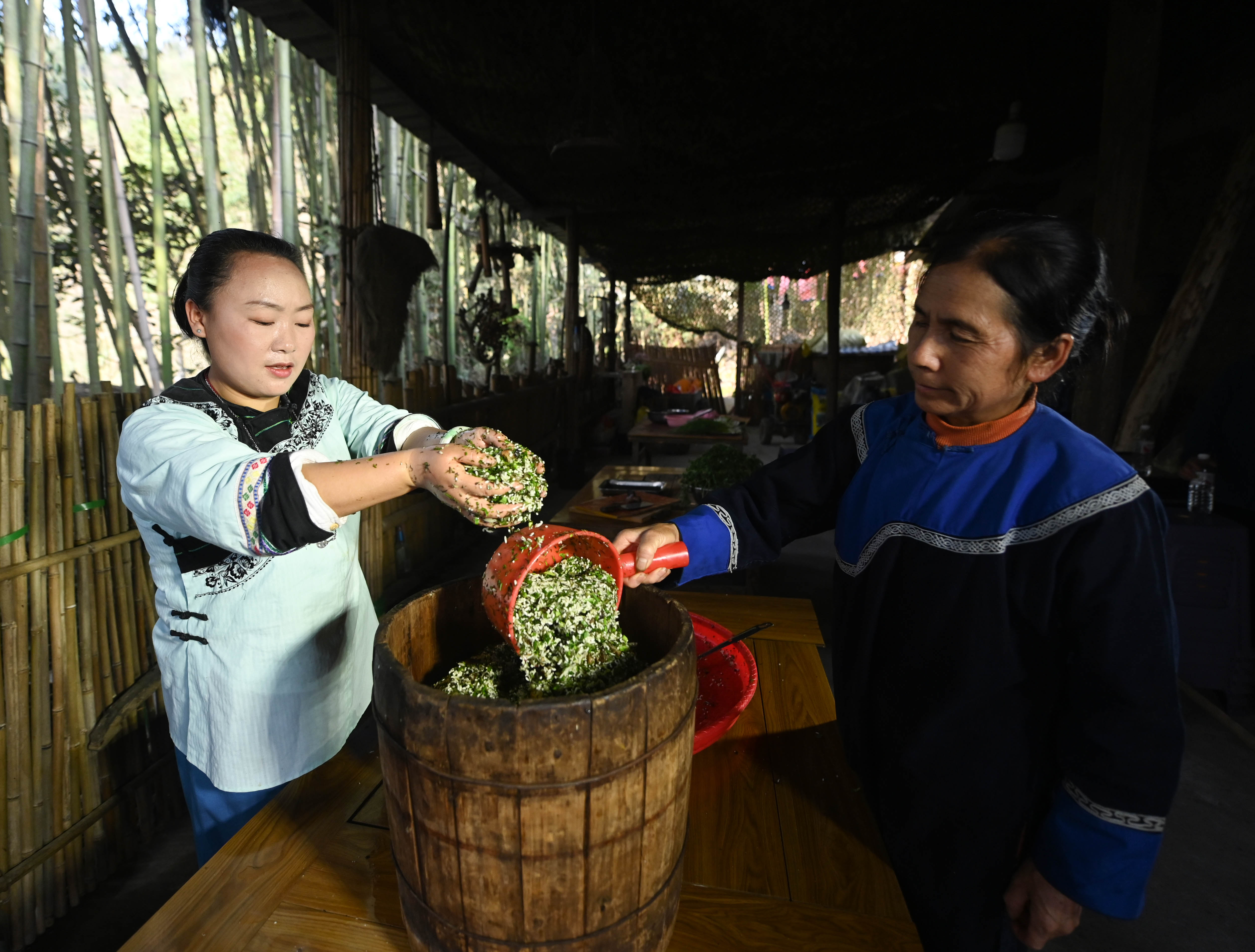 Locals put ingredients of Shefan into a wooden steamer in Songtao Miao Autonomous County, Guizhou Province on March 24, 2024. /Photo provide to CGTN 