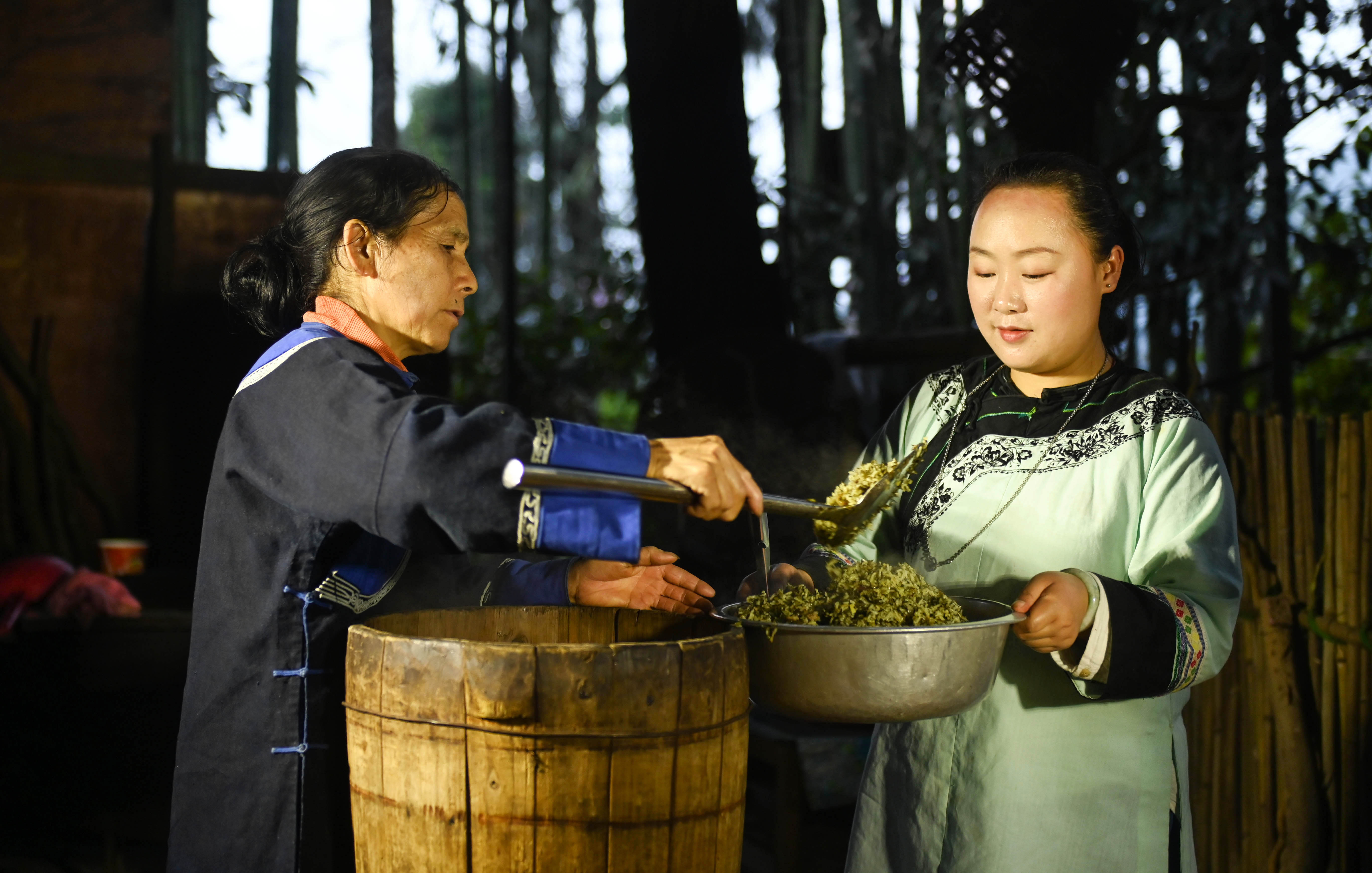 Locals put steamed Shefan into a basin in Songtao Miao Autonomous County, Guizhou Province on March 24, 2024. /Photo provide to CGTN