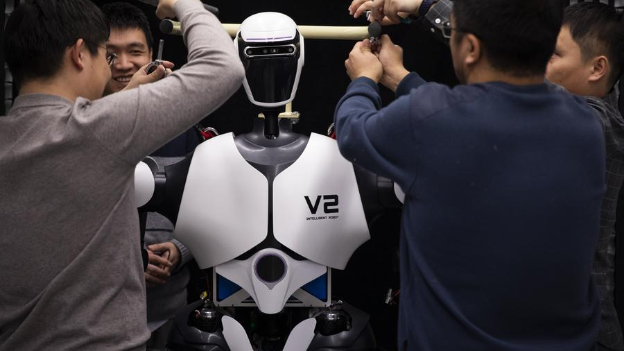 Researchers adjust a humanoid robot at an AI laboratory, January 31, 2024. /Xinhua