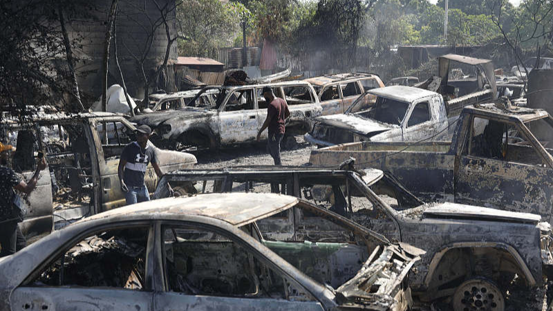 People look for salvageable pieces from burned cars at a mechanic shop that was set on fire during violence by armed gangs in Port-au-Prince, Haiti, March 25, 2024. /CFP