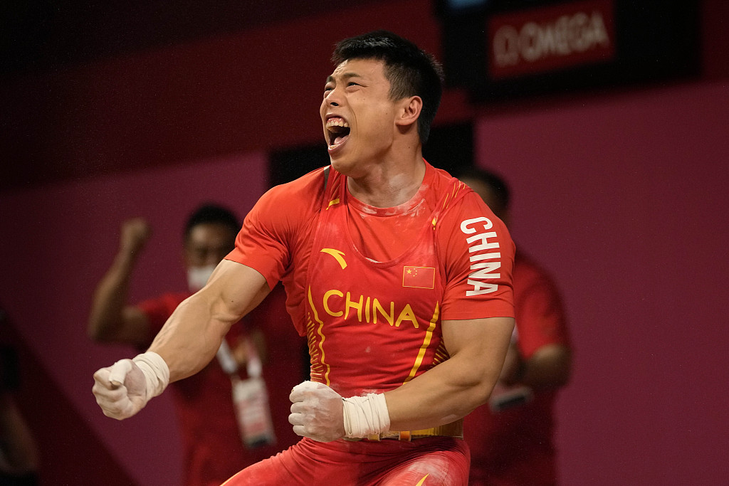 China's Shen Lijun celebrates after winning the gold medal in the men's 67 kg weightlifting event at the Olympics in Tokyo, Japan, July 25, 2021. /CFP