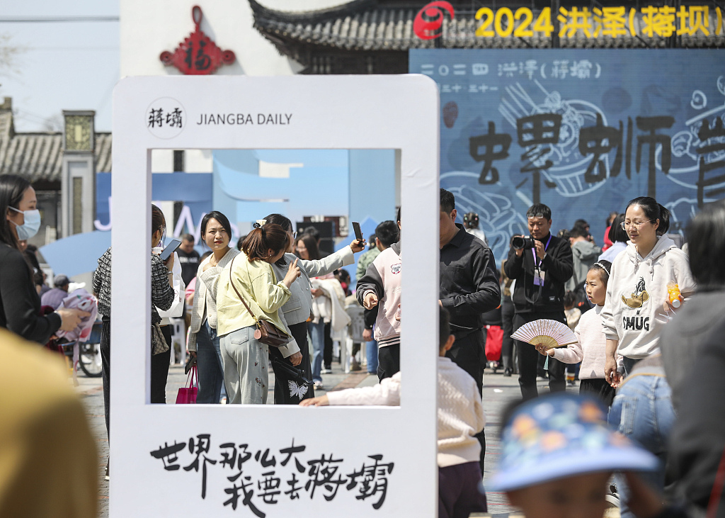 Tourists take photos at a river snail gourmet festival in Jiangba Town, Huai'an, Jiangsu Province on March 31, 2024. /CFP