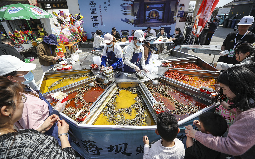 Tourists taste river snails in assorted flavors in Jiangba Town, Huai'an, Jiangsu Province on March 31, 2024. /CFP