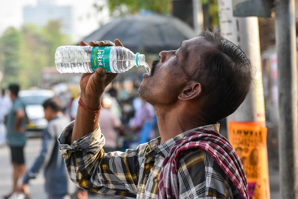A man drinks water by the road during a heat wave in Kolkata, India, April 2, 2024. /CFP