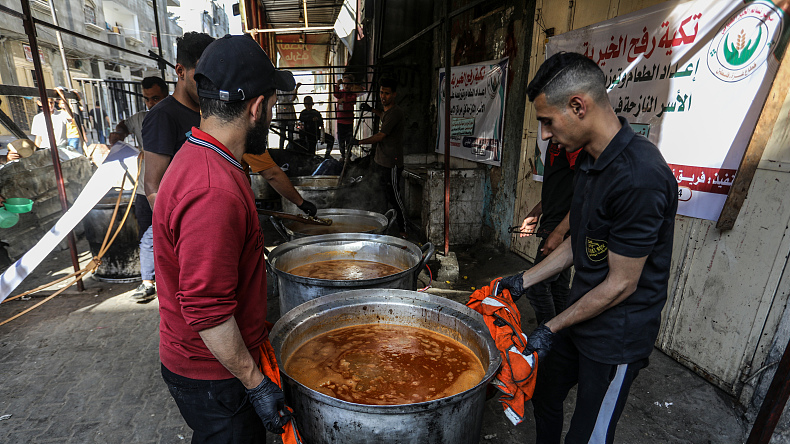 Palestinians, including children, who took refuge with their families in Rafah city, wait in line to get a bowl of food distributed by charity organizations for their families, in Rafah in the Gaza Strip, April 4, 2024. /CFP