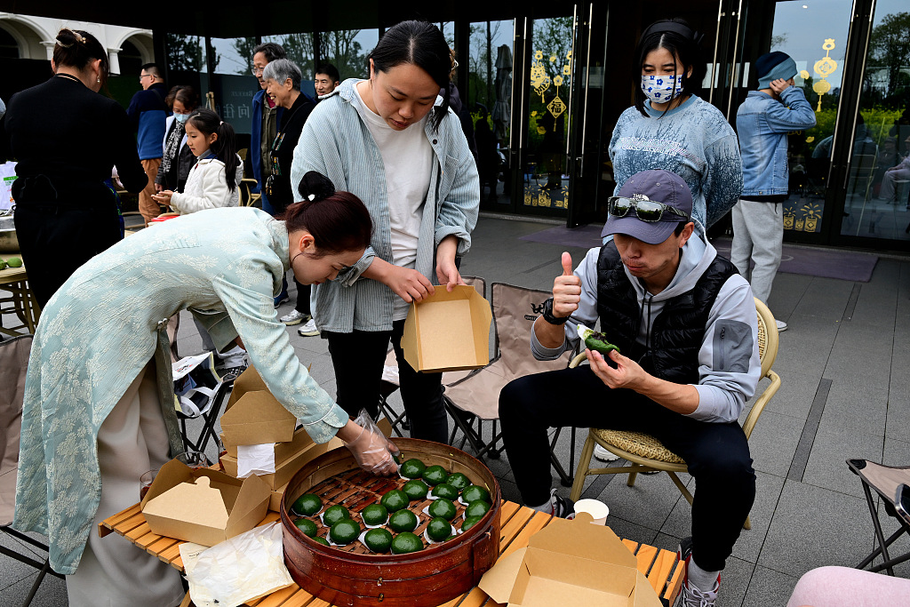 People are spotted eating and sharing qingtuan during Qingming Festival celebrations on April 4, 2024 in Jiaxing, Zhejiang Province. /CFP