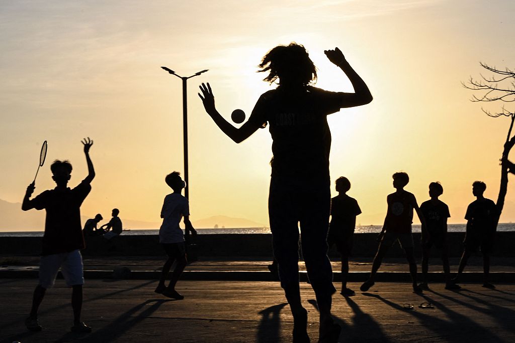 Students play volleyball along a street in Manila, the Philippines, April 5, 2024. /CFP