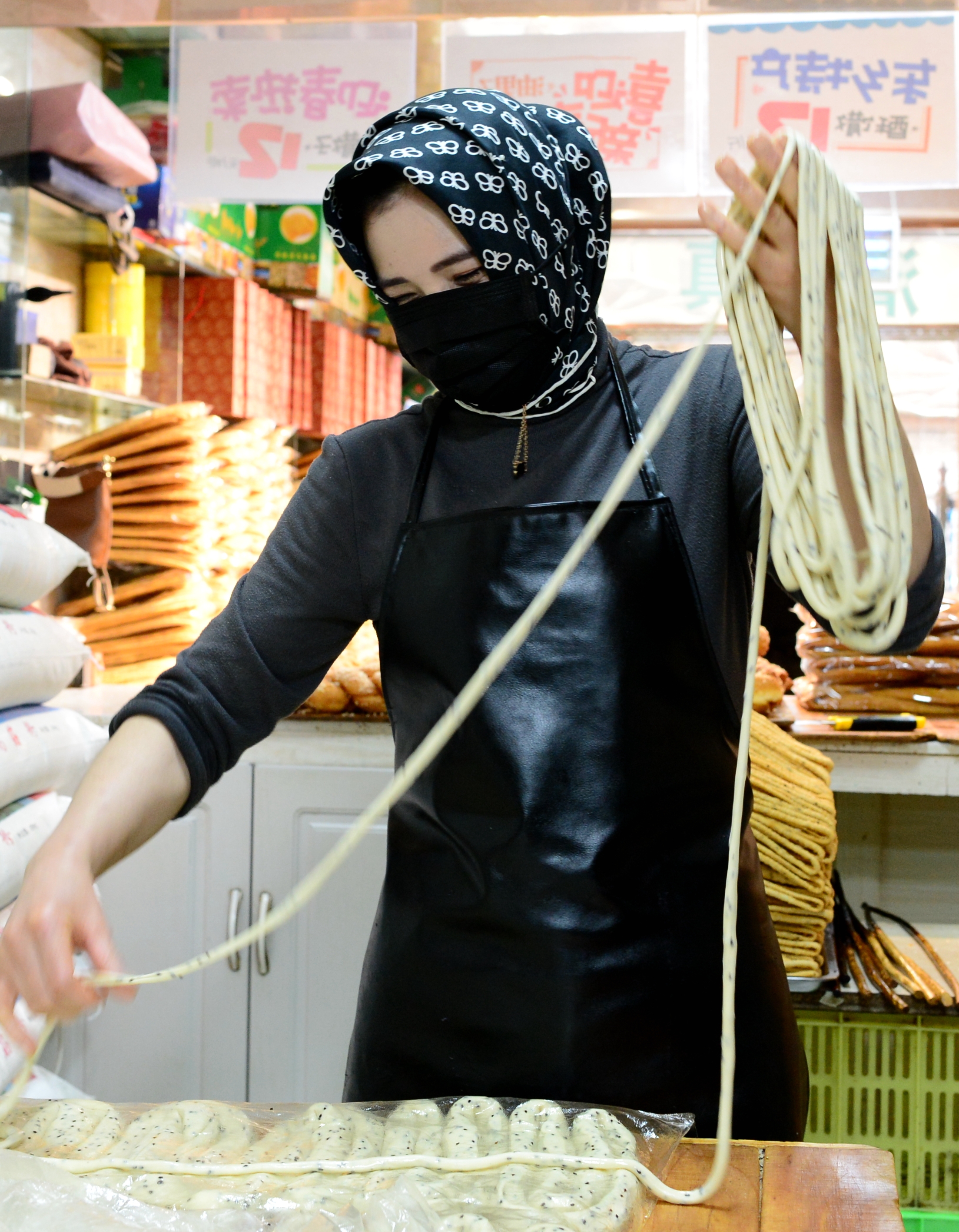 A file photo shows a chef in Lanzhou, Gansu Province makes sanzi, or fried dough twists. /IC