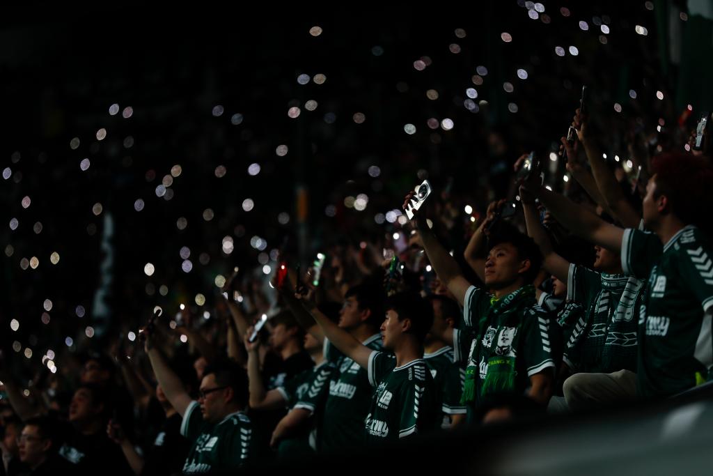 Spectators turn on their phones' flashlights during the Chinese Super League game between Beijing Guoan and Shanghai Port in memory of Yang Xue at the Workers' Stadium in Beijing, April 5, 2024. /Xinhua