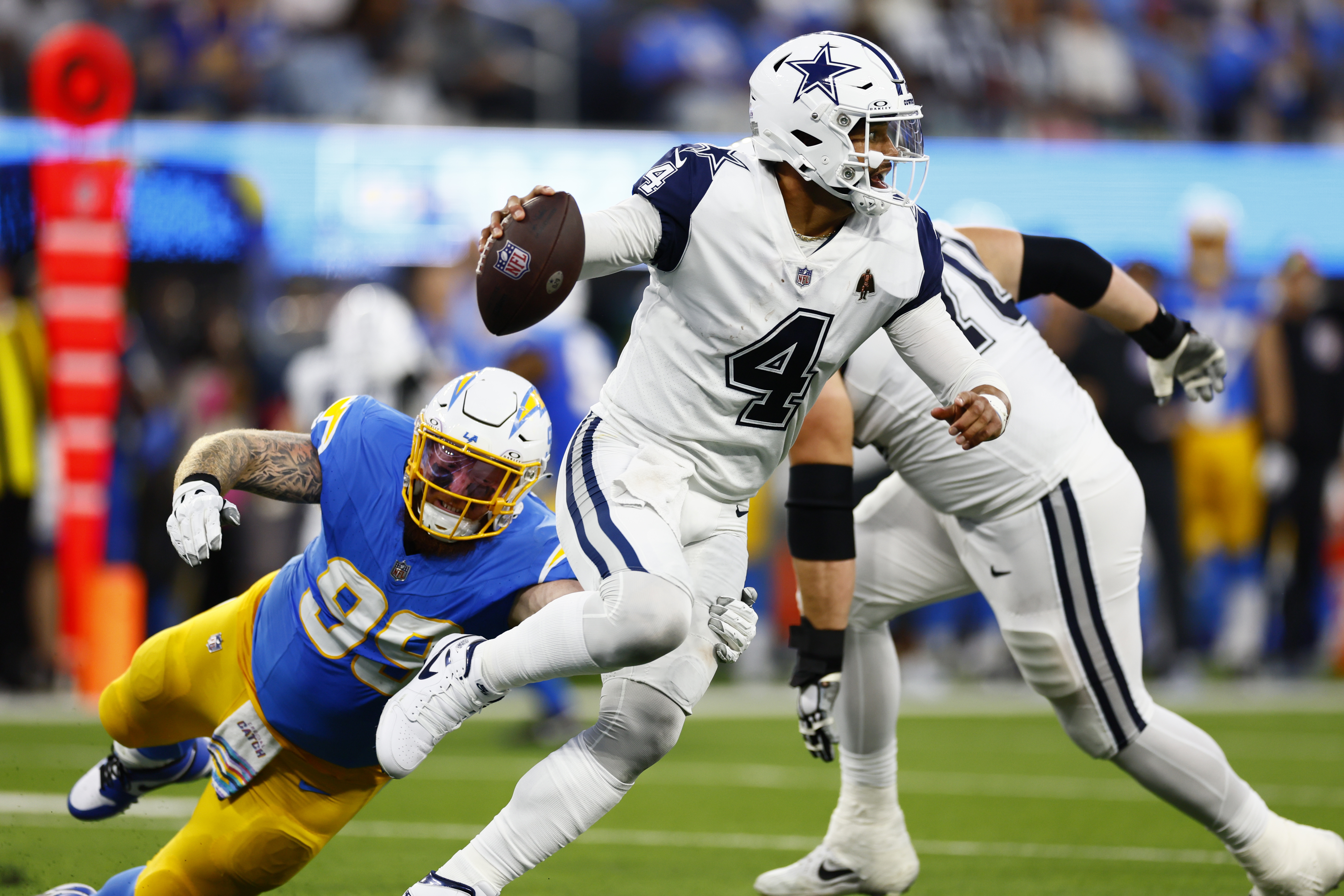 Quarterback Dak Prescott (#4) of the Dallas Cowboys dodges a tackle in the game against the Los Angeles Chargers at SoFi Stadium in Inglewood, California, October 16, 2023. /CFP