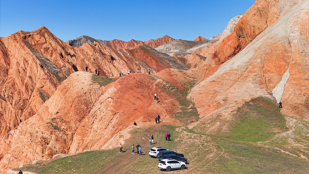 People appreciate the Danxia landform at a scenic area in Hutubi County, northwest China's Xinjiang Uygur Autonomous Region on April 5, 2024. /CFP