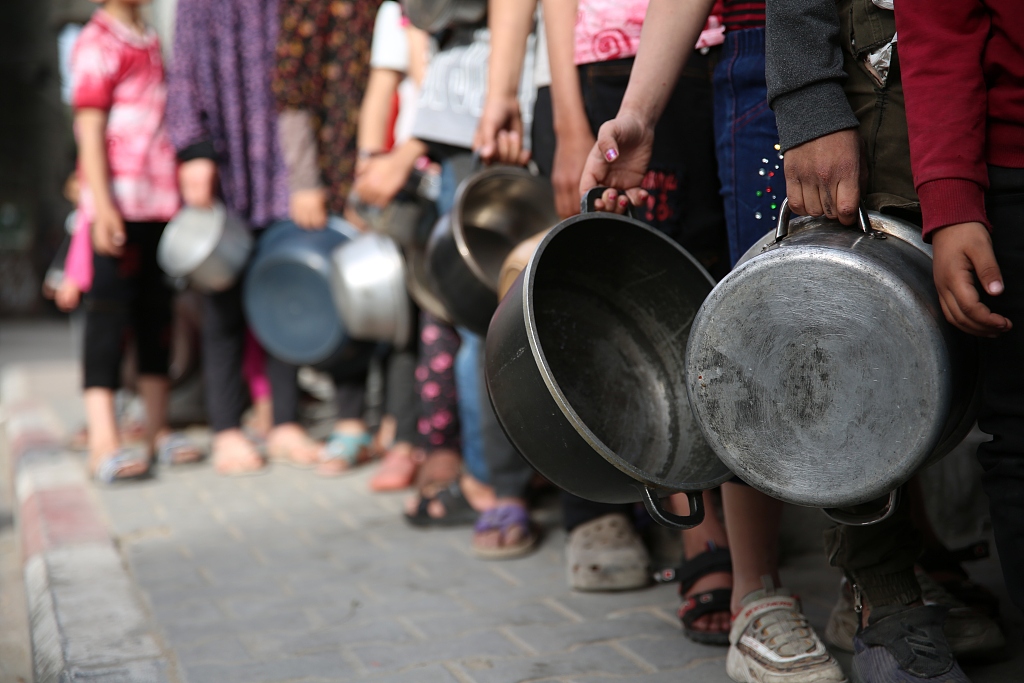 Palestinian children wait in long queues with bowls to receive food for their families from charity organizations in Gaza City, Gaza, April 5, 2024. /CFP