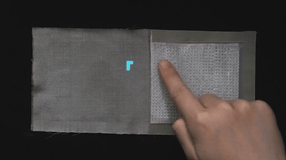 A researcher demonstrates the wireless body-coupled textile used for tactile, patterned-pixel display. /Donghua University