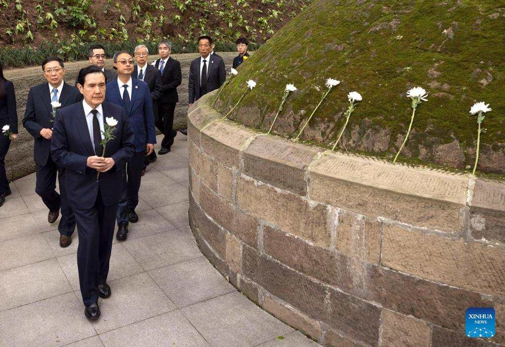 Ma Ying-jeou, former chairman of the Chinese Kuomintang party, presents a flower at the tomb of General Zhang Zizhong, a senior officer killed during the Chinese People's War of Resistance Against Japanese Aggression, while visiting a cemetery dedicated to the general, in southwest China's Chongqing Municipality, April 4, 2023. /Xinhua