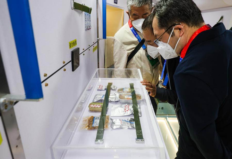Visitors look at food for taikonauts in the Tianhe core module of the 1:1 model of China's space station combination showcased at the 14th China International Aviation and Aerospace Exhibition in Zhuhai City, south China's Guangdong Province, November 9, 2022. /Xinhua