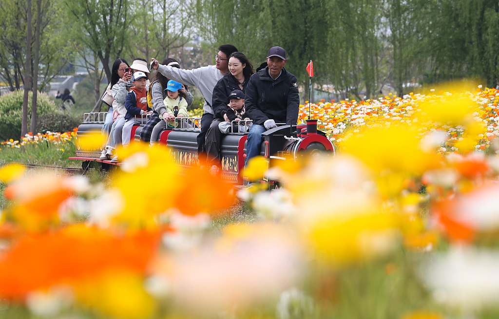 A view of tourists admiring flowers in a park of Zhenjiang, Jiangsu Province, China. / CFP