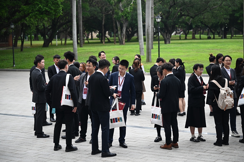 Students from the Taiwan region who are visiting the Chinese mainland with Ma Ying-jeou, former chairman of the Chinese Kuomintang party, go to the Guangzhou campus of Sun Yat-sen University for an exchange with local students, in Guangzhou, south China's Guangdong Province, April 3, 2024. /CFP
