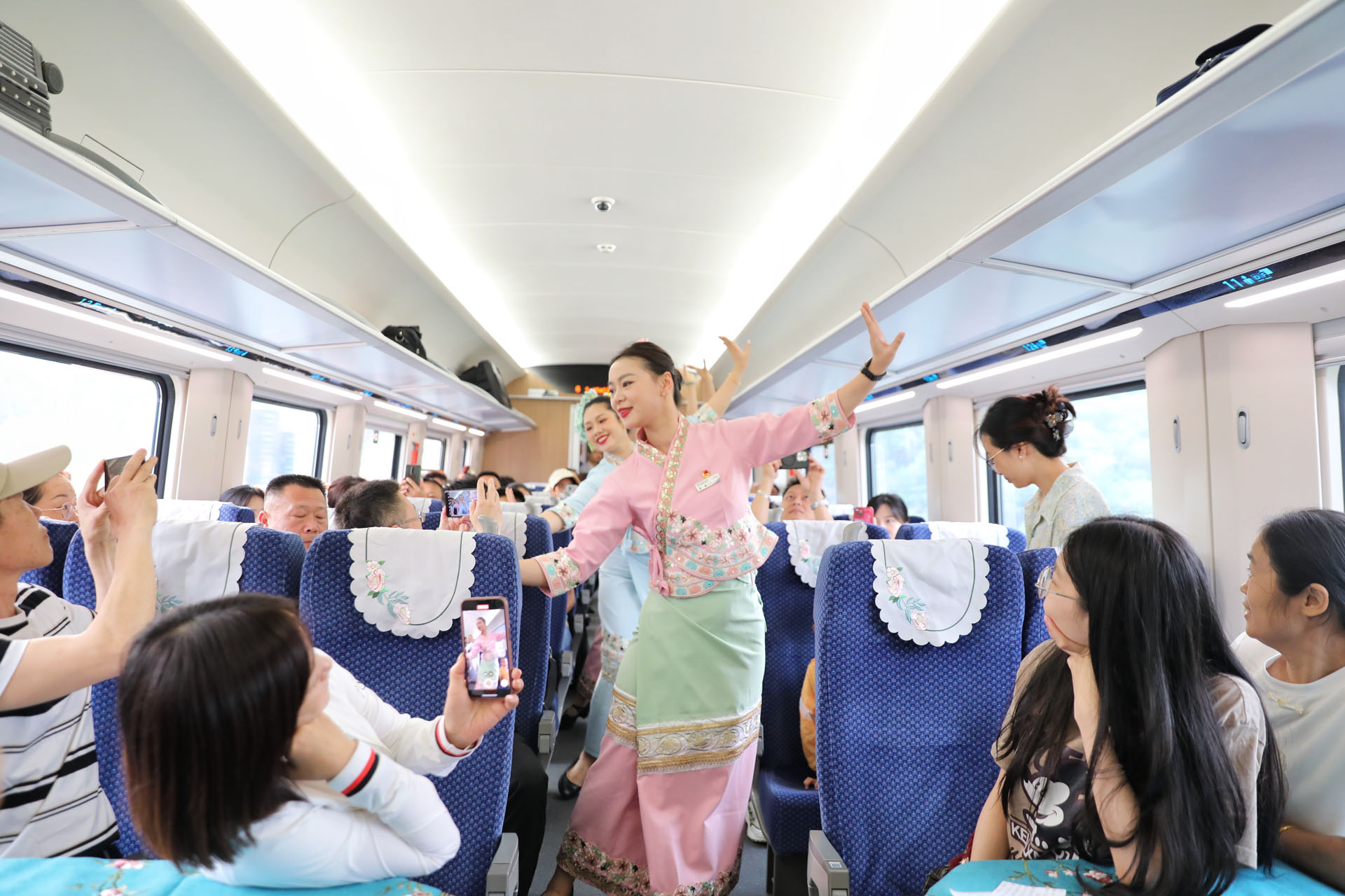 Train staff perform in front of passengers at Xishuangbanna Railway Station, southwest China's Yunnan Province, April 13, 2024. /CGTN