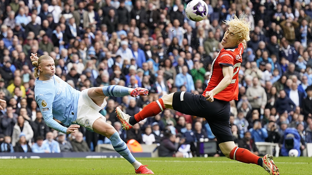 Erling Haaland (L) of Manchester City half volleys the ball into the face of Daiki Hashioka of Luton during their Premier League match at the Etihad Stadium in Manchester, England, April 13, 2024. /CFP