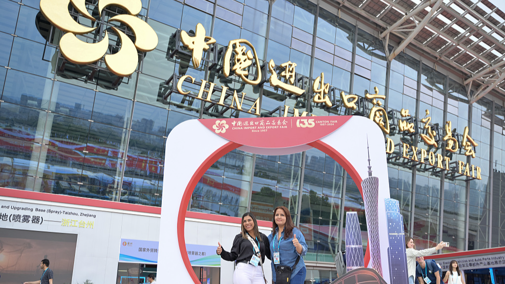 Participants pose for a picture in front of the venue for the 135th China Import and Export Fair, or Canton Fair, in Guangzhou City, South China's Guangdong Province, April 15, 2024. /CFP