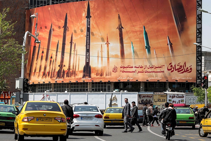 A billboard depicting named Iranian ballistic missiles in service, with text in Arabic reading 