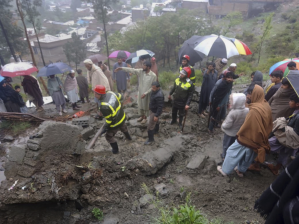 Rescue workers and locals gather to clear the rubble of a house partially damaged by landslide due to heavy rainfall in Matta, Pakistan, April 14, 2024. /CFP